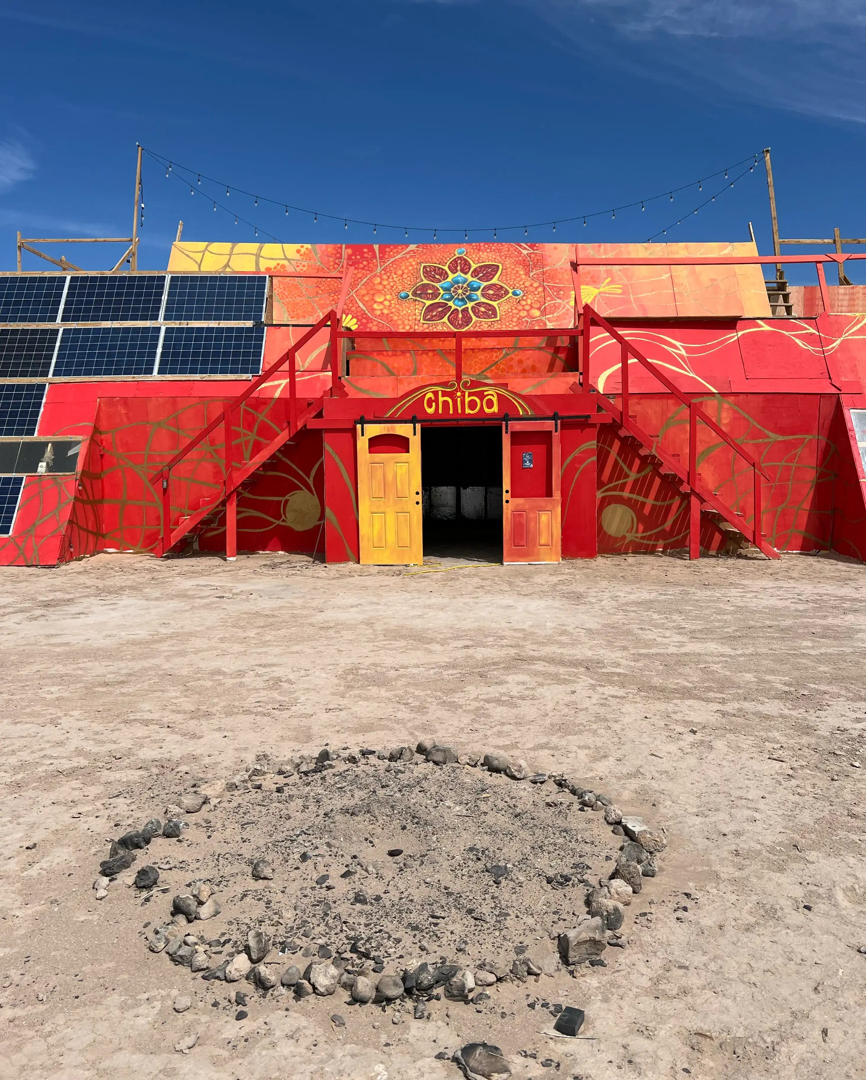 Chiba, the red mural building at Mars College, 2024, with the Mars College flower painted above the doors.