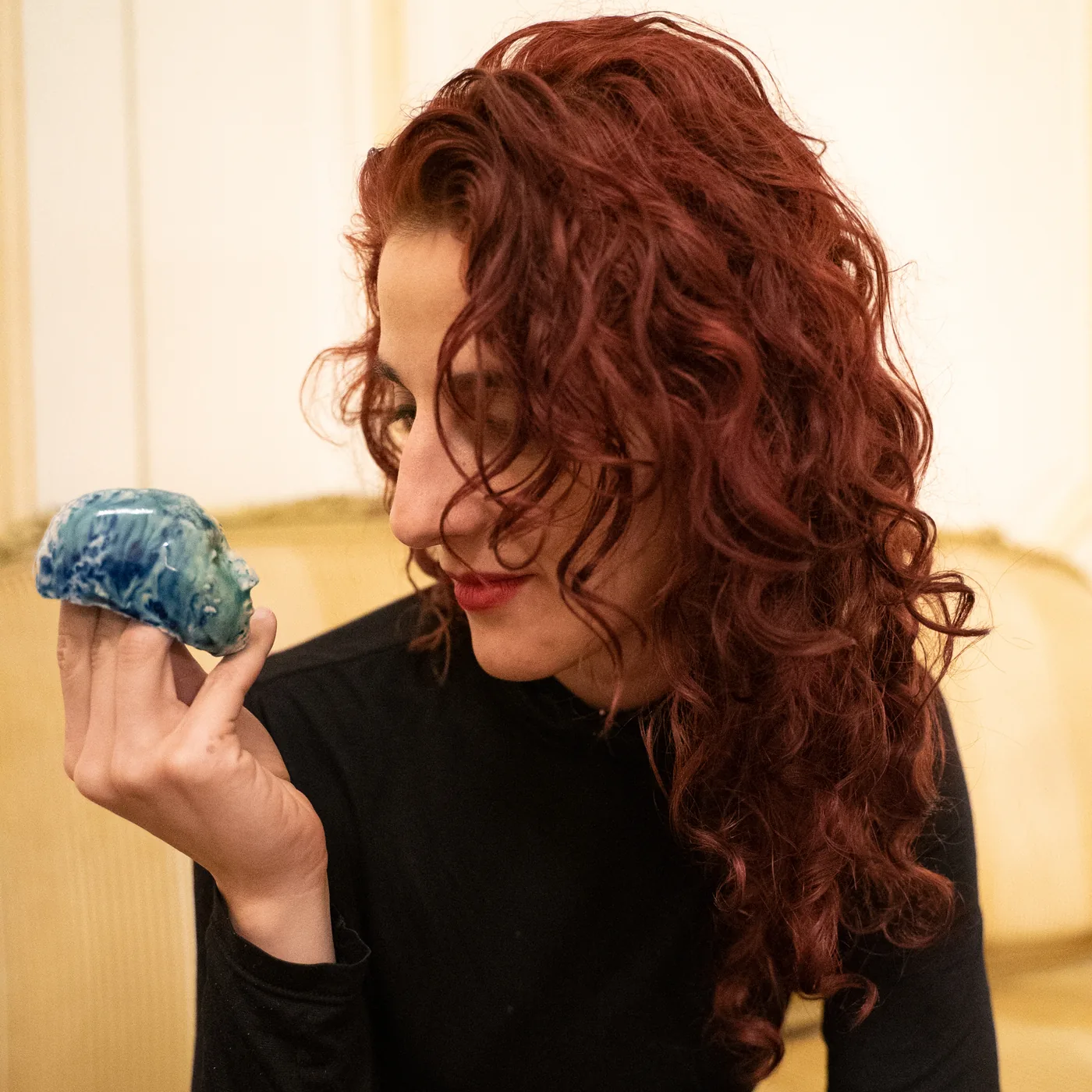 Vanessa Rosa holding a small blue ceramic head.