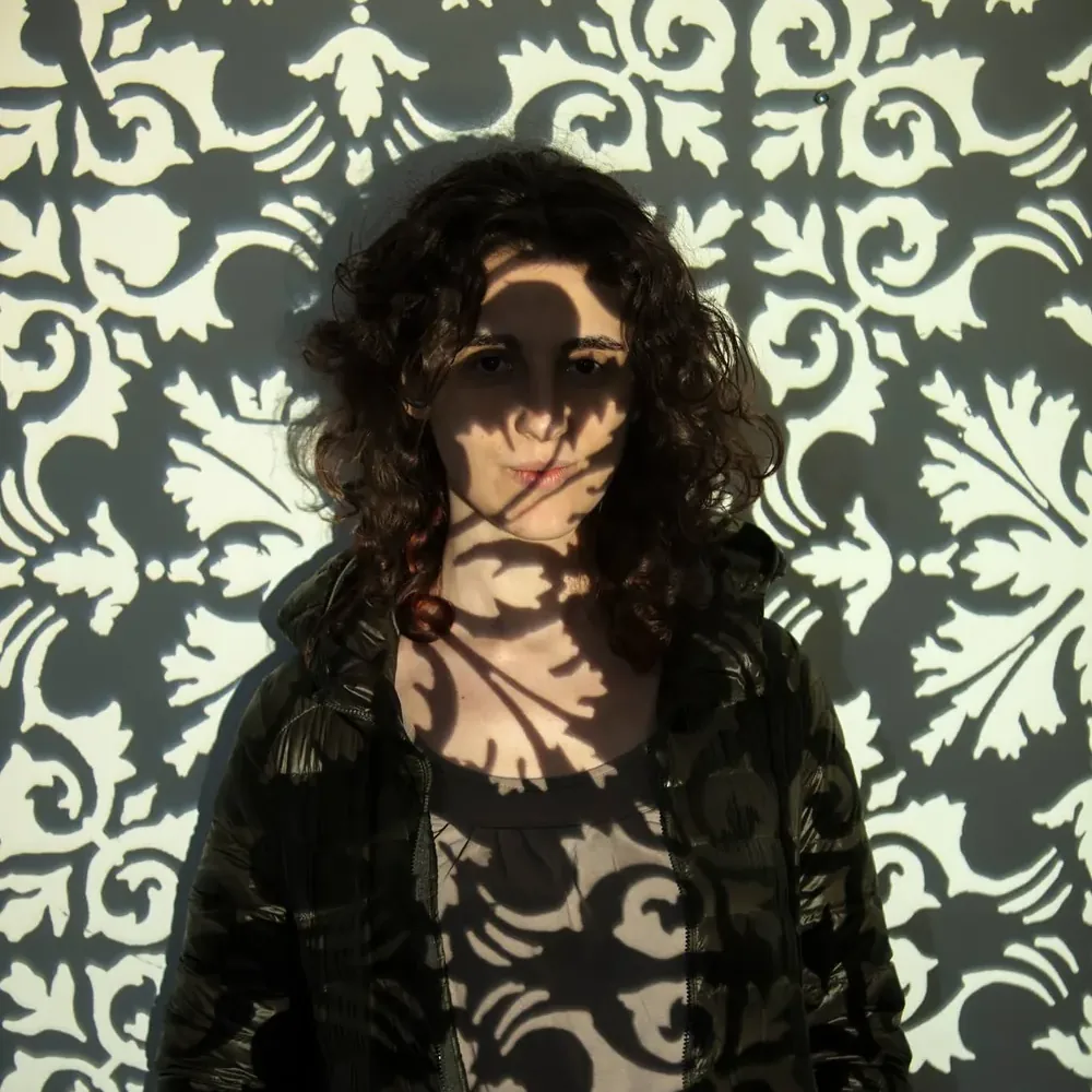 A laser-cut stencil, lit. Photograph by Marcos Muzi.