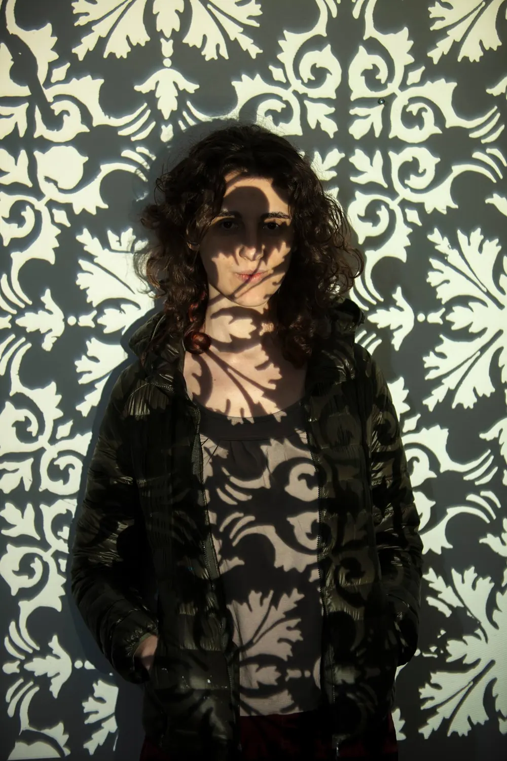 A laser-cut stencil, lit. Photograph by Marcos Muzi.