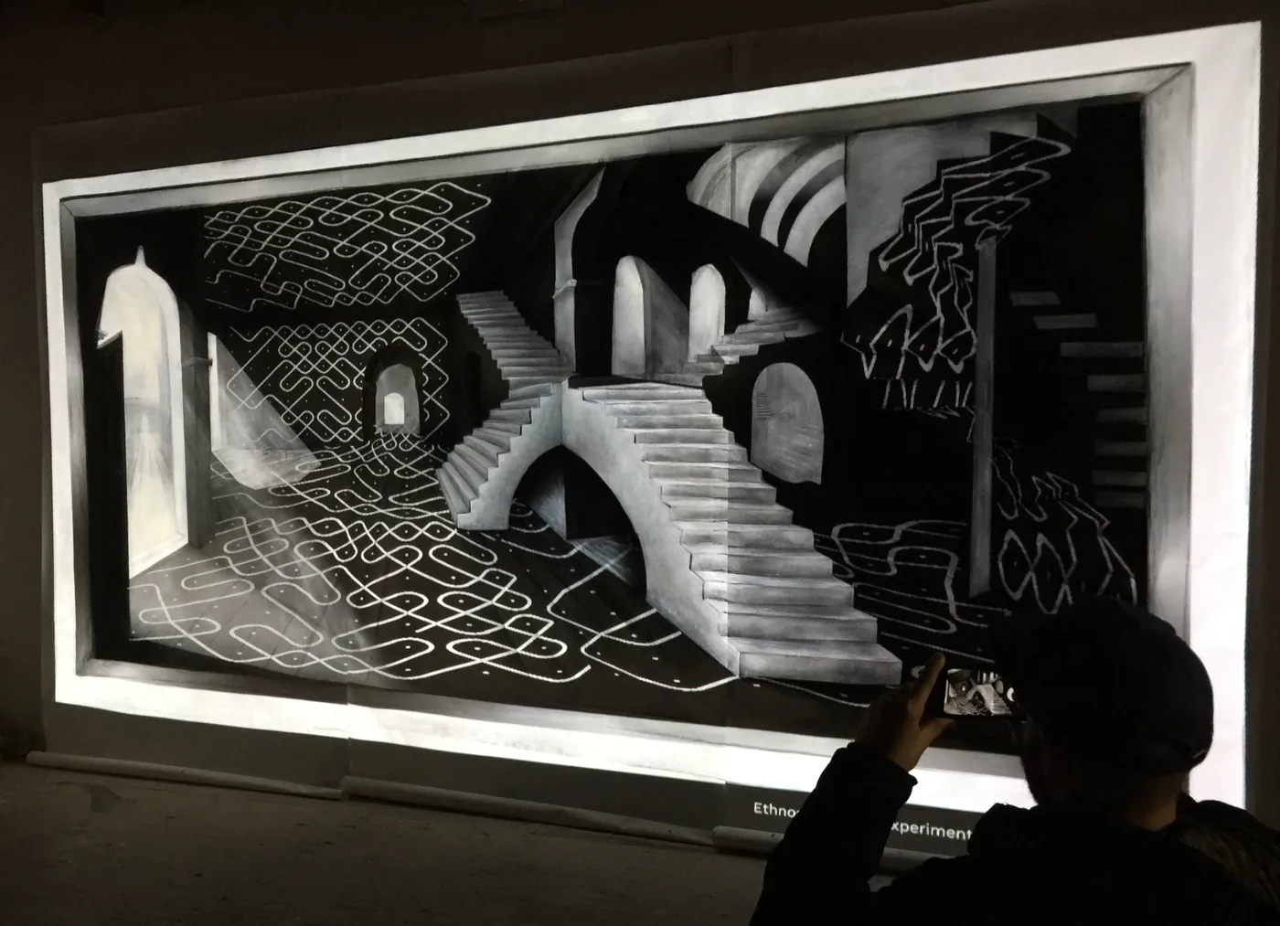 A Sona pattern projected over a painting of a receding perspective corridor.