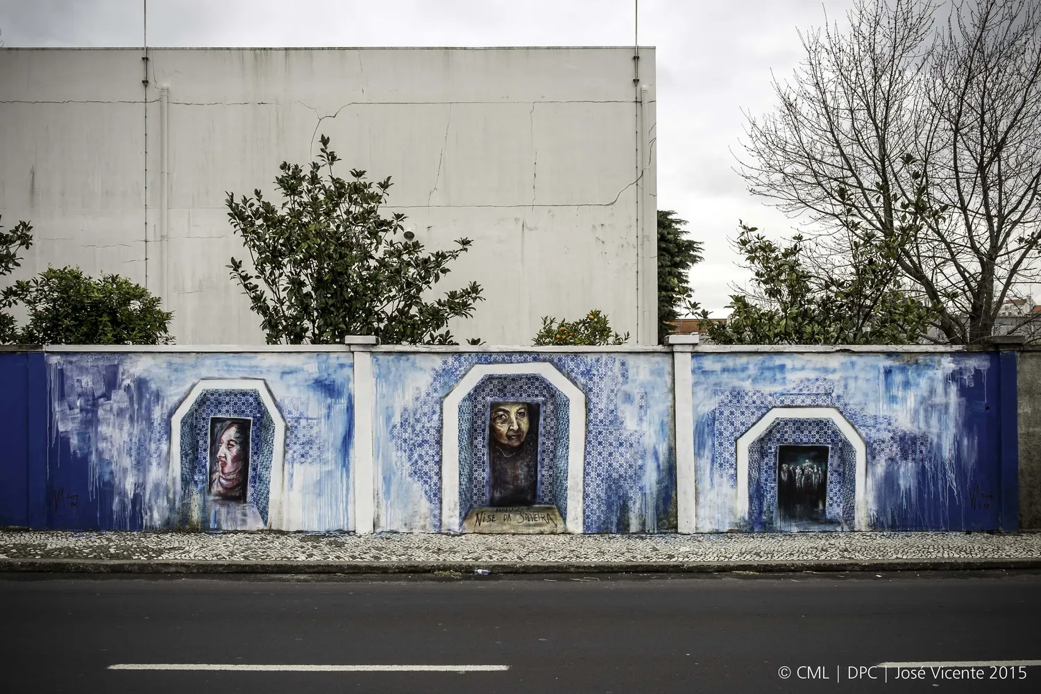 Arched niches along the same wall, each with a face inside.