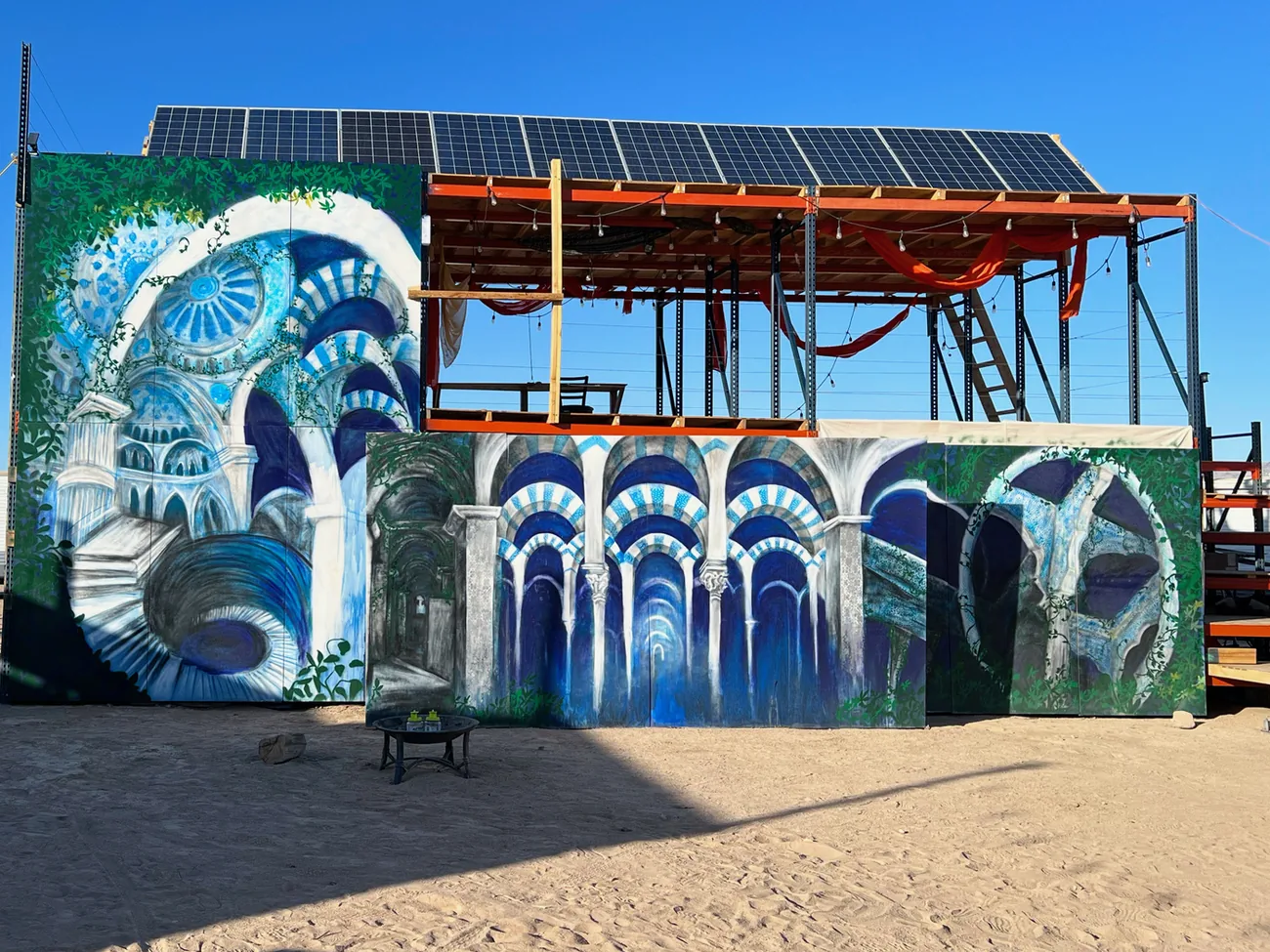 Painted blue archways on the walls of a solar-powered structure at Mars College, in the desert.
